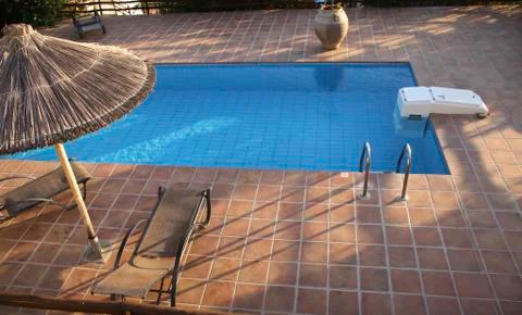 Swimming pool with deckchairs Stock Photos
