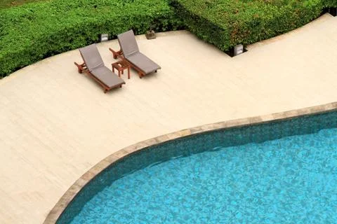 Swimming pool with deckchairs Stock Photos