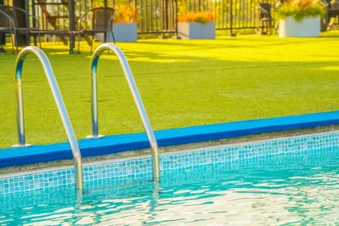 Swimming pool at the edge of the pool is artificial green grass. In the summe Stock Photos