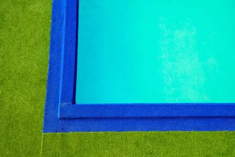 Swimming pool at the edge of the pool is artificial green grass. In the summe Stock Photos