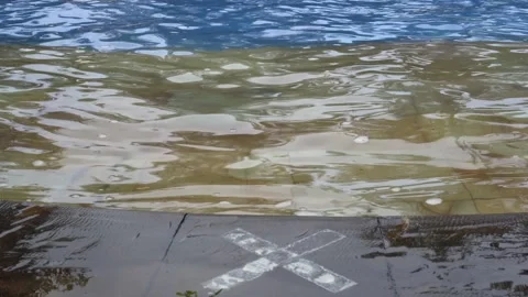 Swimming pool edge with waterflow and cross mark for safety Stock Footage 211789747