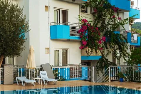 A swimming pool is in front of a building with blue balconies Stock Photos