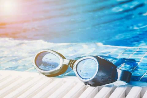 Swimming pool goggles on the poolside Stock Photos