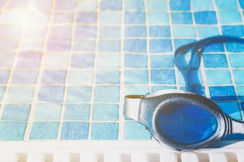 Swimming pool goggles on the poolside Stock Photos