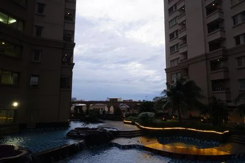 Swimming Pool with LED Lighting Between Residential Towers at Dusk in Jakarta Stock Photos