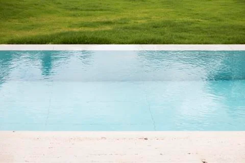 A swimming pool with poolside lawn Stock Photos
