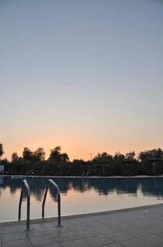 Swimming pool at sunset Stock Photos