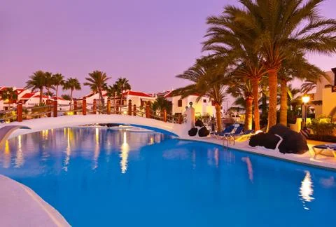 Swimming pool at sunset Stock Photos