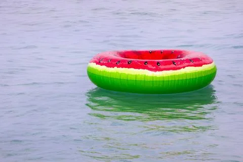 Swimming ring with a watermelon pattern on the surface of the water in the .. Stock Photos