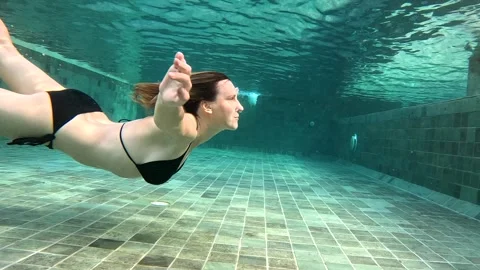 Swimming underwater in a pool, showcasing diving and swimming skills Stock Footage 324710878