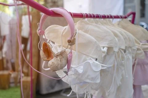 Swimsuits on a retail rack next to seashell headphones. Stock Photos
