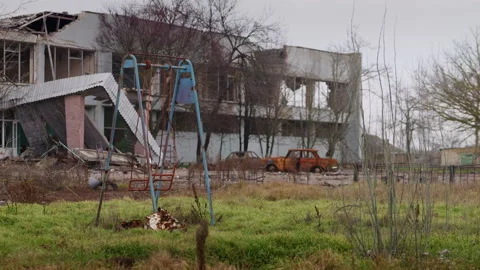 Swing at abandoned playground, rusty burnt car left at public place in Kherson Stock Footage 233367905