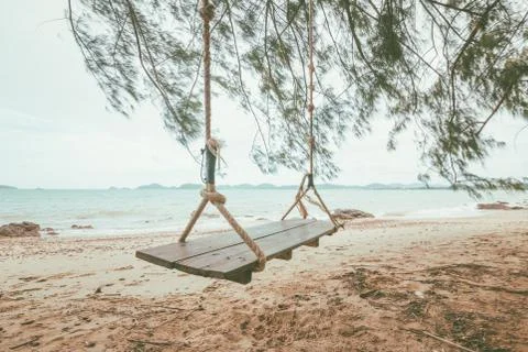 Swing on the beach with mountain back. Stock Photos