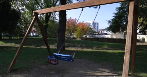 Swing for children swinging on an empty playground emptiness covid 19 lockdow Stock Footage 150205931