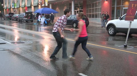 Swing dancing in the rain in the streets barefoot. Stock Footage 40336676