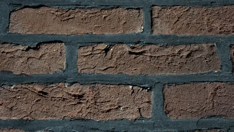 Swing downwards over a rough red brick wall with dark grey joints Stockbeeldmateriaal 119116286