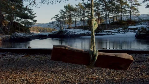 A swing in the foreground with a nice snowy background. sunset Stock Footage 233898465