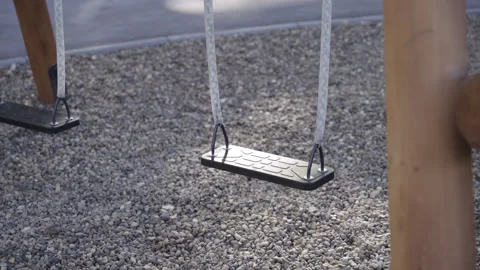 Swing with plastic seat hangs on ropes on urban playground Видео 330285099