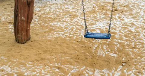 A swing in the playground at the first snow Foto stock