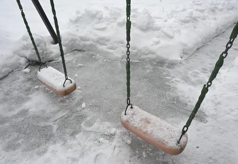 Swing on the playground in the yard in winter Stock Photos