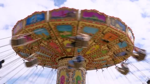Swing roller coaster going round on summer day Stock Footage 84650734