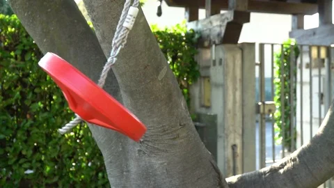 Swing in round shape red colored blowing in wind as the sun sets Stock Footage 94928935