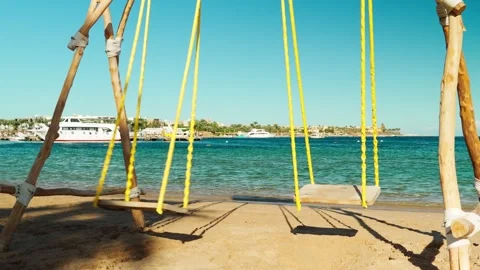 Swing on a sandy beach overlooking the Red Sea. Vídeo Stock 330061967