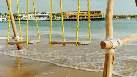 Swing on a sandy beach overlooking the Red Sea. 스톡 동영상 330062158