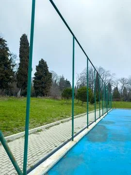 A swing set frame is visible in a park. It stands empty with a blue surface b Stock Photos