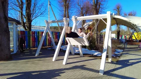 Swing set fun at a playground during a sunny day Stock Footage 332066855