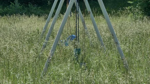 A Swing Set in Tall Grass in Abandoned Park Stock Footage 76378774