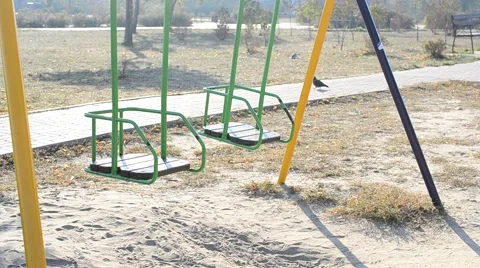 Swing set - two kids swing seats swaying empty Stock Footage 56246596