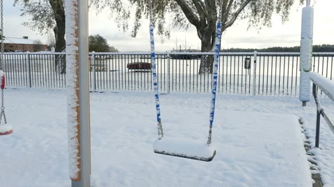 Swing sets on children playground covered with snow, abandoned children playgrou Stockbeeldmateriaal 102043697