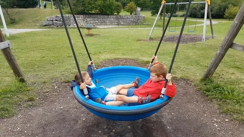 Swing Sets with Children's Playgrounds in a Public Park Stock Footage 99781807