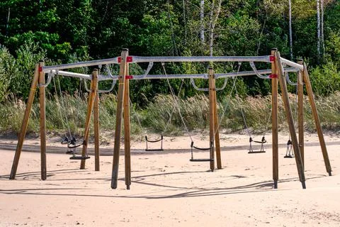 Swing for six places on an empty beach. Stock Photos