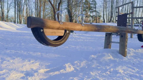 A swing for two on a playground in winter Stock Footage 329608455