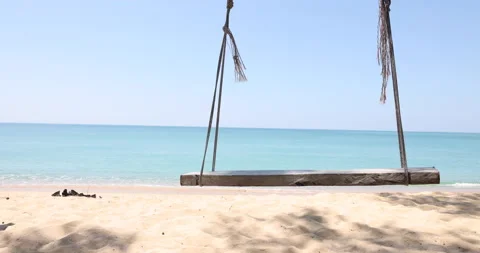 Swing in the wind on a soft beach with a blue sea against the blue sky. And w Stock Footage 149645591