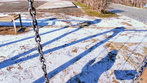 Swing in the winter shadow of a child Stock Footage 220200206