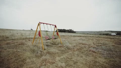 Swing without children. Swing in an abandoned place. Abandoned playground. Stock-Footage 165741499