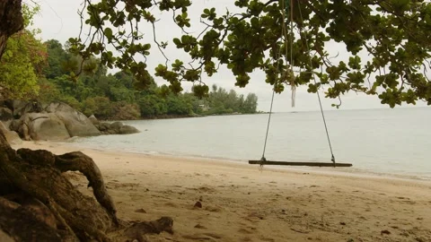 Swinging on the beach on a cloudy day view of Phuket Bay Thailand Stock Footage 223822050