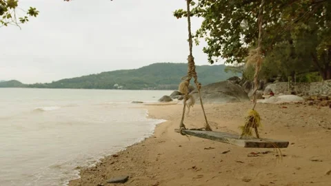 Swinging on the beach on a cloudy day view of Phuket Bay Thailand Stock Footage 223822567