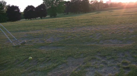 Swinging at driving range in setting sun Stock Footage 693357