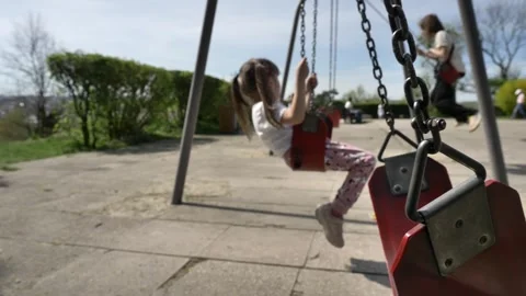 Swinging empty swing against the background of children swinging Vídeo Stock 273598790