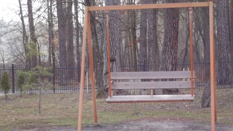 Swinging empty swing in the park Stock Footage 74065624