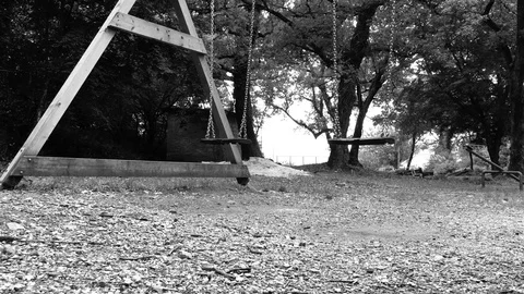 Swinging empty swings at the park Stock Footage 89911556