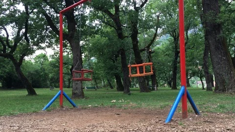 Swinging empty swings at the park Stock Footage 89914061