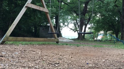 Swinging empty swings at the park Stock Footage 89915937