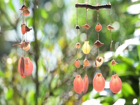 Swinging of hanging mobile seashells on colorful blurred background 库存影片 75861985