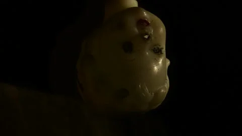 Swinging head of the doll in the glancing light of the lantern Stock Footage 143258712