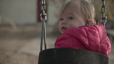 Swinging kid looking back at camera 1 Stock Footage 142655079